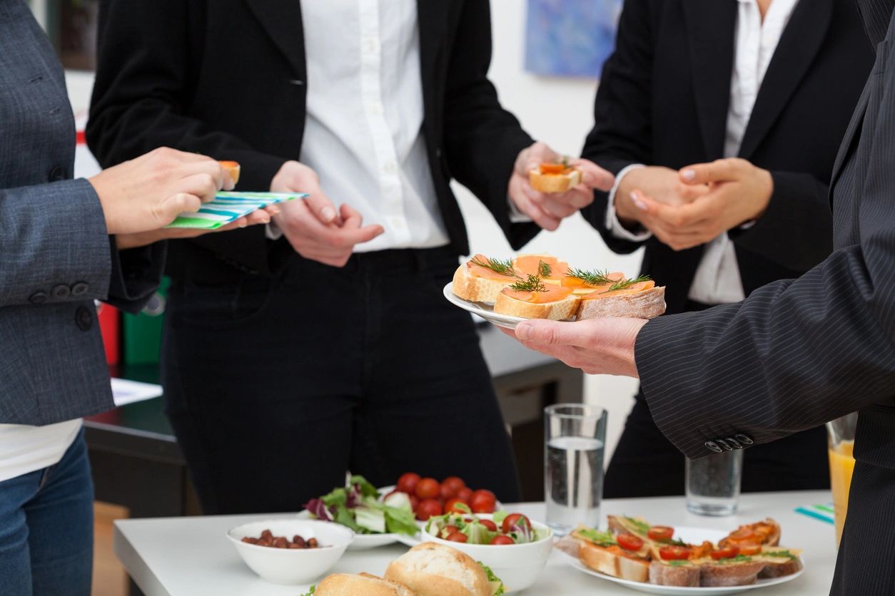 People in suits enjoying finger foods at a social event.
